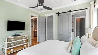 a bedroom with a bed and a flat screen tv at Southern Sol in Watersound Beach
