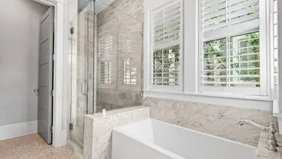 a white bathroom with a tub and a window at Southern Sol in Watersound Beach