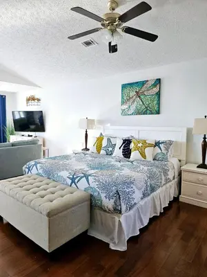a bedroom with a bed with a ceiling fan at You, Me & the Sea! in Panama City Beach