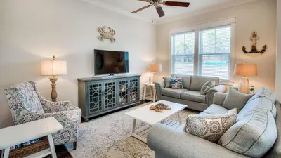 a living room with a couch and a tv at Prominence 14B in Rosemary Beach