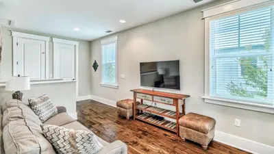 a living room with a couch and a tv at NatureWalk at Seagrove 985 in Santa Rosa Beach
