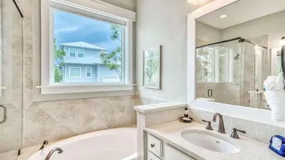 a bathroom with a tub and a sink and a window at NatureWalk at Seagrove 985 in Santa Rosa Beach