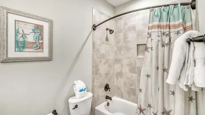 a bathroom with a shower curtain and a toilet at NatureWalk at Seagrove 985 in Santa Rosa Beach