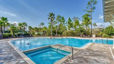 a swimming pool at a resort with palm trees at NatureWalk at Seagrove 985 in Santa Rosa Beach