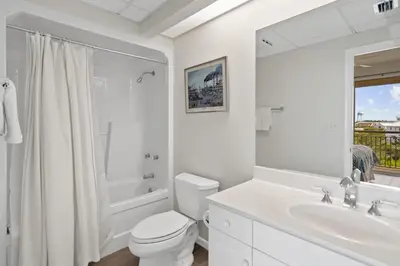 a white bathroom with a toilet and a sink at High Pointe 431 Gulf Views in Rosemary Beach
