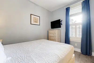 a bedroom with a bed and a tv and a window at Spacious Home with Private Pool dog-friendly 2 Blocks to Beach in Santa Rosa Beach