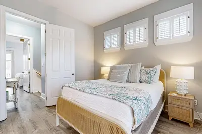 a bedroom with a bed and two windows at Spacious Home with Private Pool dog-friendly 2 Blocks to Beach in Santa Rosa Beach