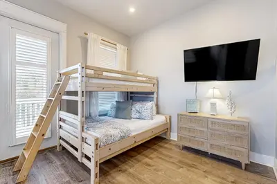 a bedroom with a bunk bed and a flat screen tv at Spacious Home with Private Pool dog-friendly 2 Blocks to Beach in Santa Rosa Beach