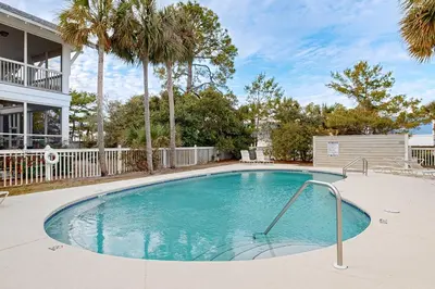 a swimming pool with palm trees and a house at Spacious Home with Private Pool dog-friendly 2 Blocks to Beach in Santa Rosa Beach