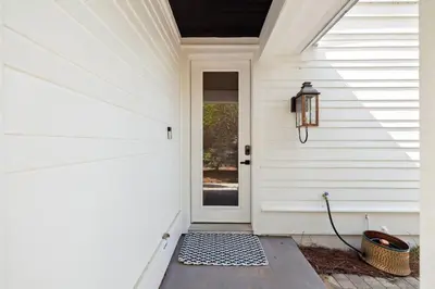 a front door of a white house with a basket at Beach,Please in Rosemary Beach