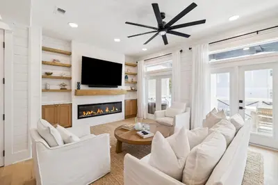 a living room with white furniture and a fireplace at Beach,Please in Rosemary Beach