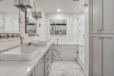 a white bathroom with two sinks and a shower at Stunning beachfront condo with shared pool & beach access in Santa Rosa Beach