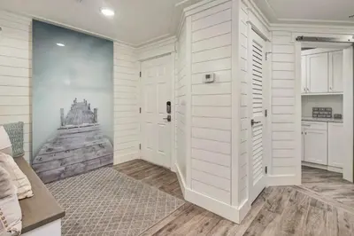 a hallway with a door leading into a room with a kitchen at Stunning beachfront condo with shared pool & beach access in Santa Rosa Beach