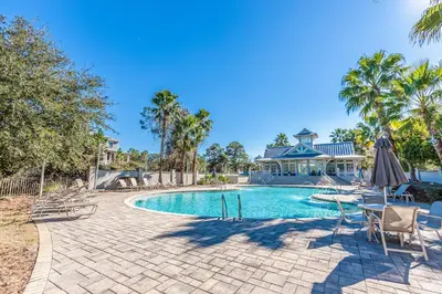 a pool with chairs and an umbrella and a house at New Cottage Near 30A Rosemary Beach with 2 Master Suites in Inlet Beach