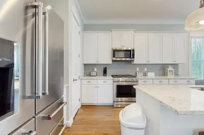 a kitchen with white cabinets and a stainless steel refrigerator at New Cottage Near 30A Rosemary Beach with 2 Master Suites in Inlet Beach