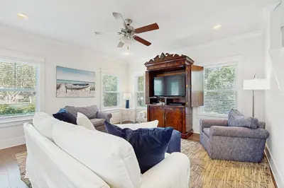 a living room with white furniture and a flat screen tv at Home with pool & dock access - blocks to beach Powell Lake & state park in Inlet Beach