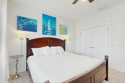 a bedroom with a large bed with white sheets at Home with pool & dock access - blocks to beach Powell Lake & state park in Inlet Beach