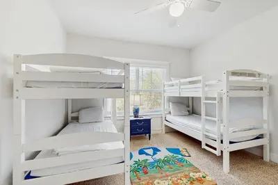 a bedroom with white bunk beds and a window at Home with pool & dock access - blocks to beach Powell Lake & state park in Inlet Beach