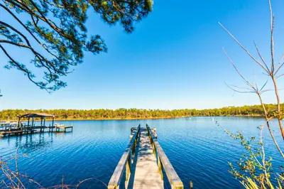 a dock in the middle of a lake at Home with pool & dock access - blocks to beach Powell Lake & state park in Inlet Beach