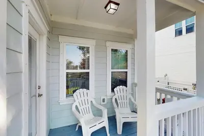 two white chairs sitting on the front porch of a house at Home with pool & dock access - blocks to beach Powell Lake & state park in Inlet Beach