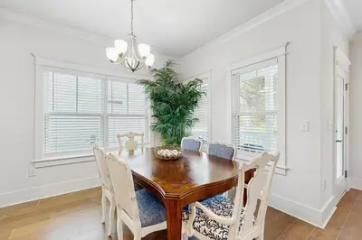 a dining room with a wooden table and chairs at Home with pool & dock access - blocks to beach Powell Lake & state park in Inlet Beach