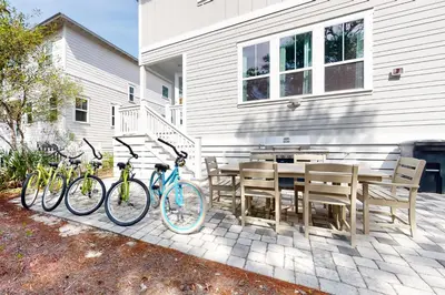 two bikes parked next to a table and chairs at Lovely Two-Story Home with Porches Access to Pool & Dock in Inlet Beach