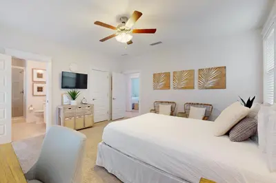 a bedroom with a white bed and a ceiling fan at Brand-new house on Powell Lake near beach & 30A with pool W&D & gym in Inlet Beach