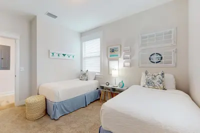 a bedroom with two beds and a desk in it at Brand-new house on Powell Lake near beach & 30A with pool W&D & gym in Inlet Beach