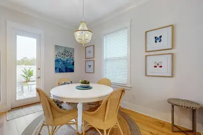 a dining room with a white table and chairs at Brand-new house on Powell Lake near beach & 30A with pool W&D & gym in Inlet Beach