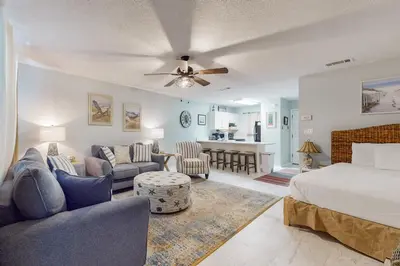 a bedroom with a bed and a living room at Beautiful coastal studio condo with pool in Santa Rosa Beach