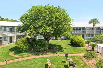 a park in front of a building with a tree at Beautiful coastal studio condo with pool in Santa Rosa Beach