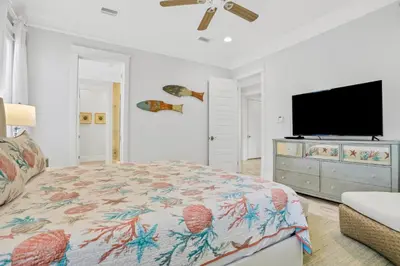 a bedroom with a bed and a flat screen tv at Relaxing getaway outdoor pool access gym bikes central AC & W&D in Inlet Beach