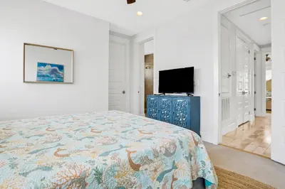 a bedroom with a bed and a flat screen tv at Relaxing getaway outdoor pool access gym bikes central AC & W&D in Inlet Beach