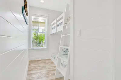 a white staircase in a room with white walls at Relaxing getaway outdoor pool access gym bikes central AC & W&D in Inlet Beach