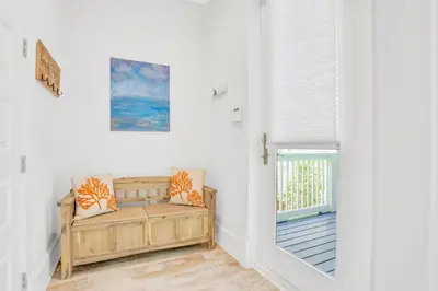 a white room with a bench and a door at Relaxing getaway outdoor pool access gym bikes central AC & W&D in Inlet Beach