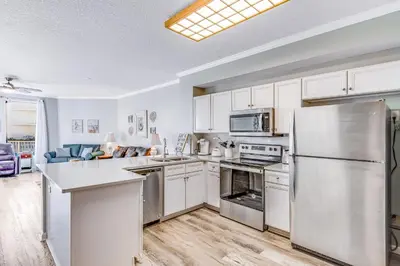 a kitchen with white cabinets and stainless steel appliances at First-floor condo with sauna gym pool tennis & pickleball in Santa Rosa Beach
