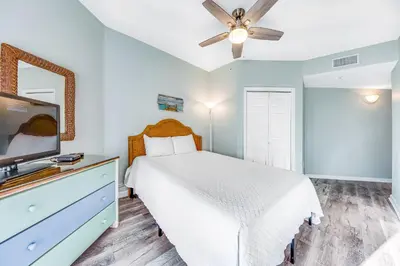 a bedroom with a white bed and a ceiling fan at First-floor condo with sauna gym pool tennis & pickleball in Santa Rosa Beach