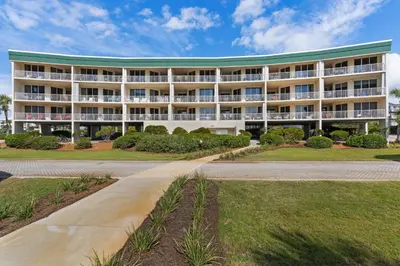 a large white building with a green roof at Condo with 2 stunning pools hot tub gym partial Gulf view & pickleball in Santa Rosa Beach