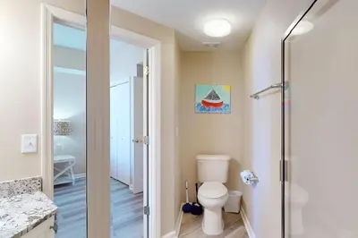 a bathroom with a toilet and a walk in shower at Gulf-front 3-bedroom condo with bonus bunk room & pickleball in Santa Rosa Beach