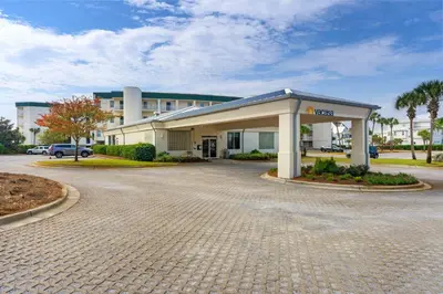 a building with a parking lot in front of it at Gulf-front 3-bedroom condo with bonus bunk room & pickleball in Santa Rosa Beach