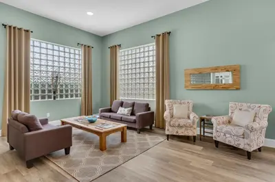 a living room with chairs and a table at Gulf-front 3-bedroom condo with bonus bunk room & pickleball in Santa Rosa Beach