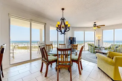 a dining room with a table and chairs and the ocean at Gulf-front 3-bedroom condo with balconies off each bedroom & pickleball in Santa Rosa Beach