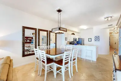 a dining room and kitchen with a table and chairs at Dog-friendly 4th-floor 3-bedroom condo with stunning Gulf views & pickleball in Santa Rosa Beach