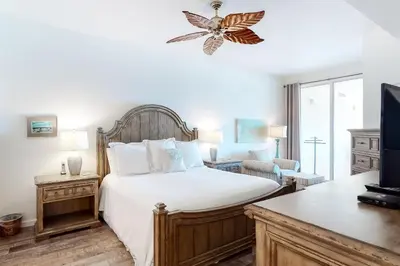 a bedroom with a large bed and a room with a tv at Dog-friendly 4th-floor 3-bedroom condo with stunning Gulf views & pickleball in Santa Rosa Beach