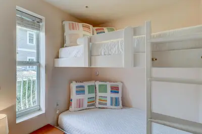 a small bedroom with bunk beds and a window at Two-bedroom with bunks balcony overlooking pool & on-site pickleball in Santa Rosa Beach