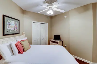 a bedroom with a white bed and a ceiling fan at Gorgeous 3-bedroom condo with stunning view spacious balcony & pickleball in Santa Rosa Beach