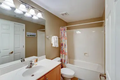 a bathroom with a sink and a toilet and a mirror at Gorgeous 3-bedroom condo with stunning view spacious balcony & pickleball in Santa Rosa Beach