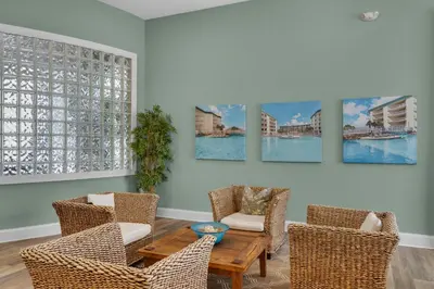 a living room with chairs and a table and paintings on the wall at Gorgeous 3-bedroom condo with stunning view spacious balcony & pickleball in Santa Rosa Beach