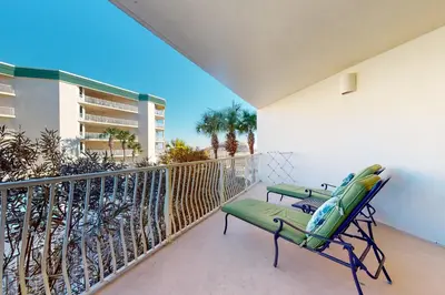 a balcony with a chair and surfboards on it at Charming two-bedroom with bunks balcony overlooking pool & pickleball in Santa Rosa Beach