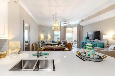 a kitchen with a sink and a living room at Amazing views at this renovated 4rth-floor condo with lagoon pool & pickleball in Santa Rosa Beach